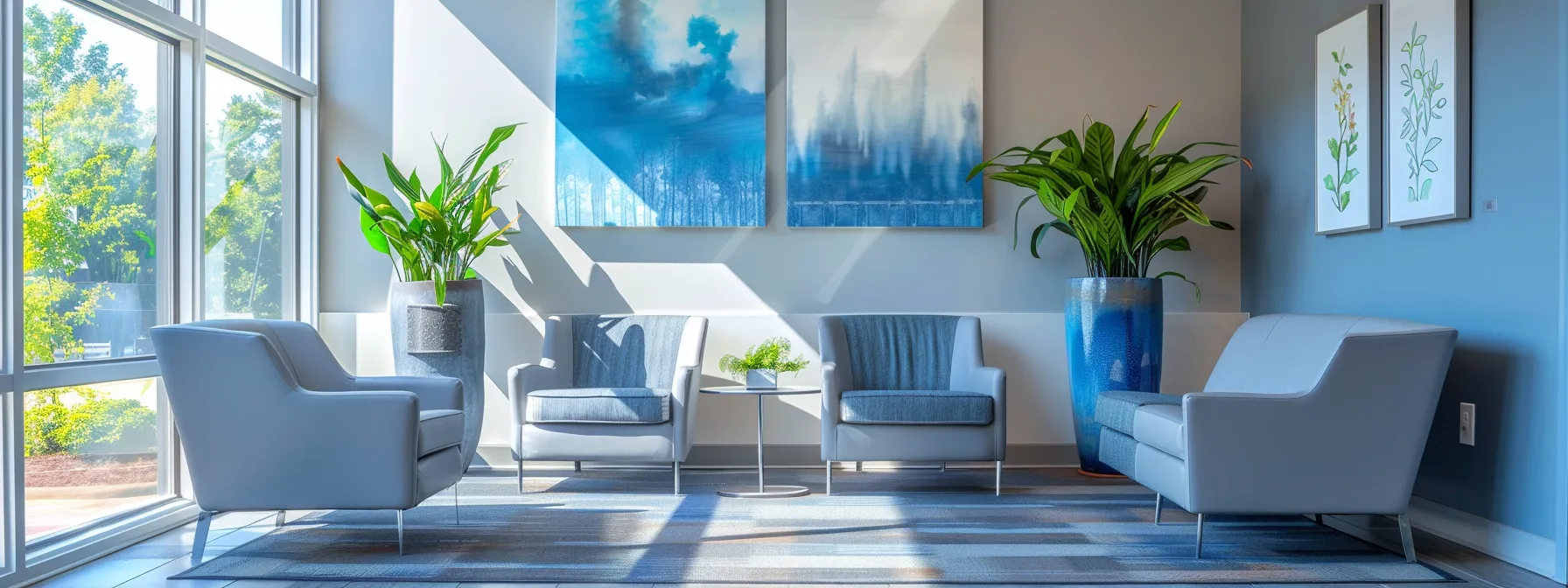 a warm and inviting therapy office in tennessee, featuring comfortable modern seating in calming blue and grey tones, large windows allowing natural sunlight to flood the clean, serene space adorned with abstract art and peaceful indoor plants, all captured with a soft focus to enhance feelings of tranquility.